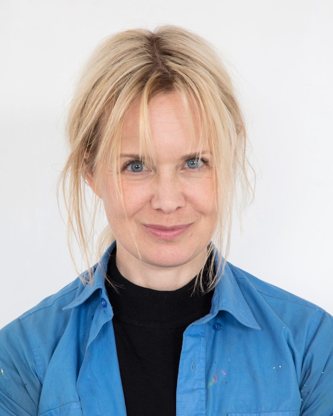 Ljushårig kvinna med blå skjorta.