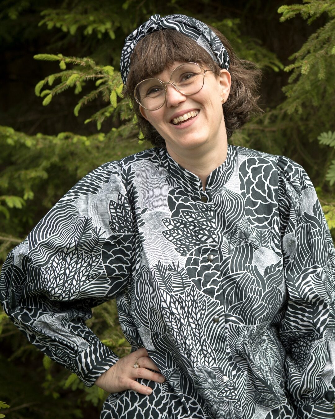 Leende kvinna i mönstrad tröja.